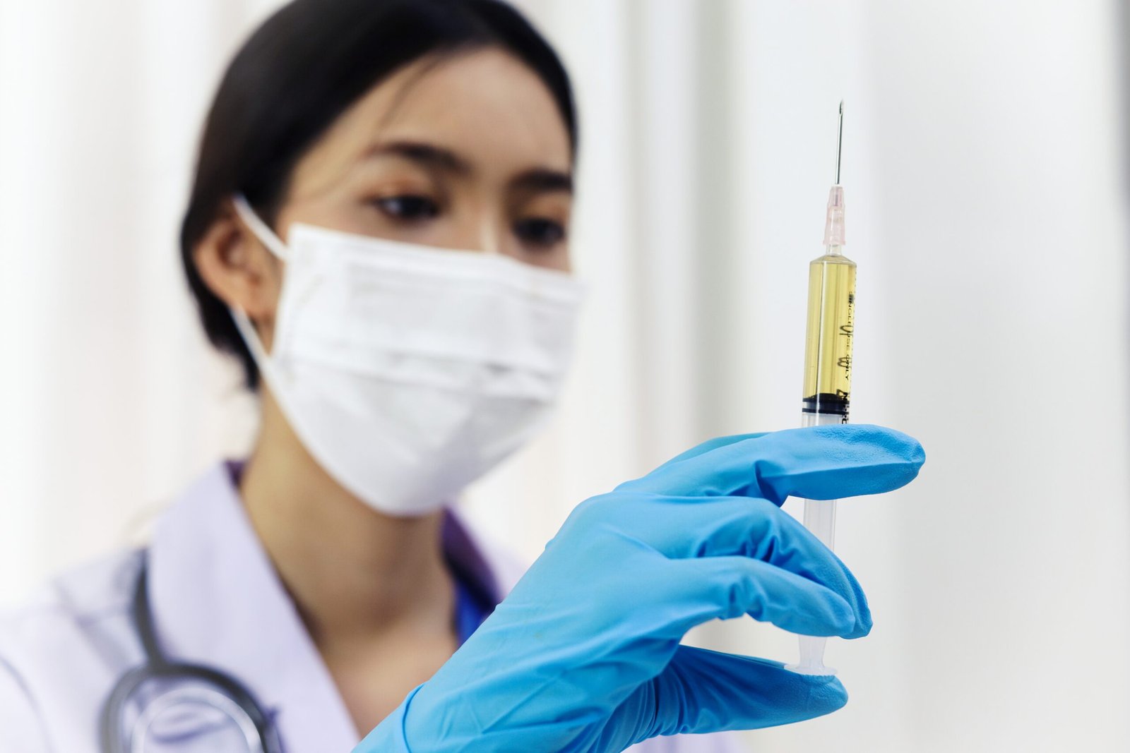Hand holding syringe and vaccine treatment from Coronavirus covi